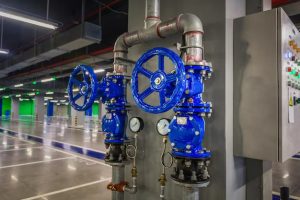 A photo of two blue valves and a control panel in industrial area