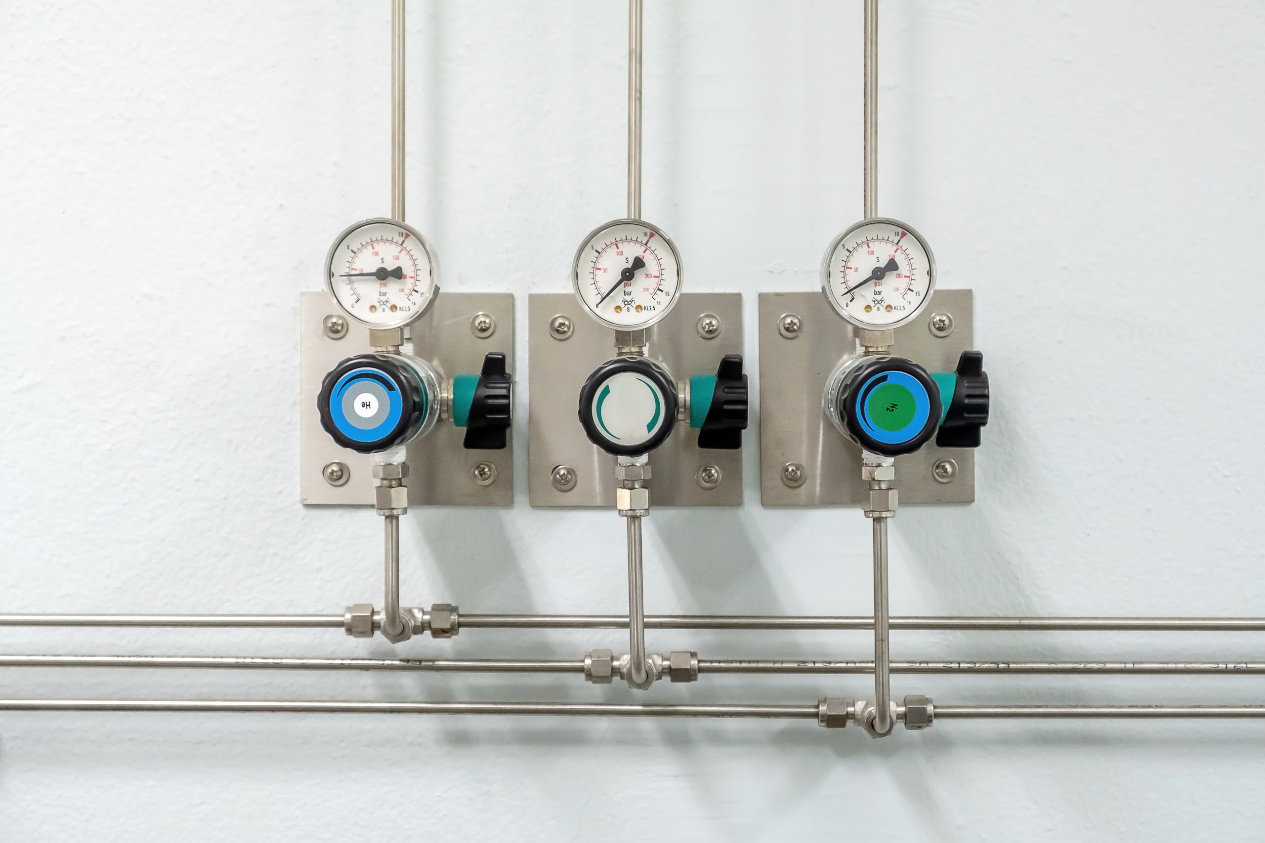 Valves of nitrogen, Helium, Oxygen ( Air Zero) pipes and Gas Pressure Meter with Regulator for monitoring measure pressure production process in Chemistry Laboratory room